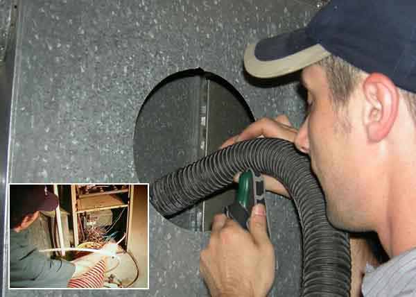 Professional air duct cleaning vacuuming the furnace interior